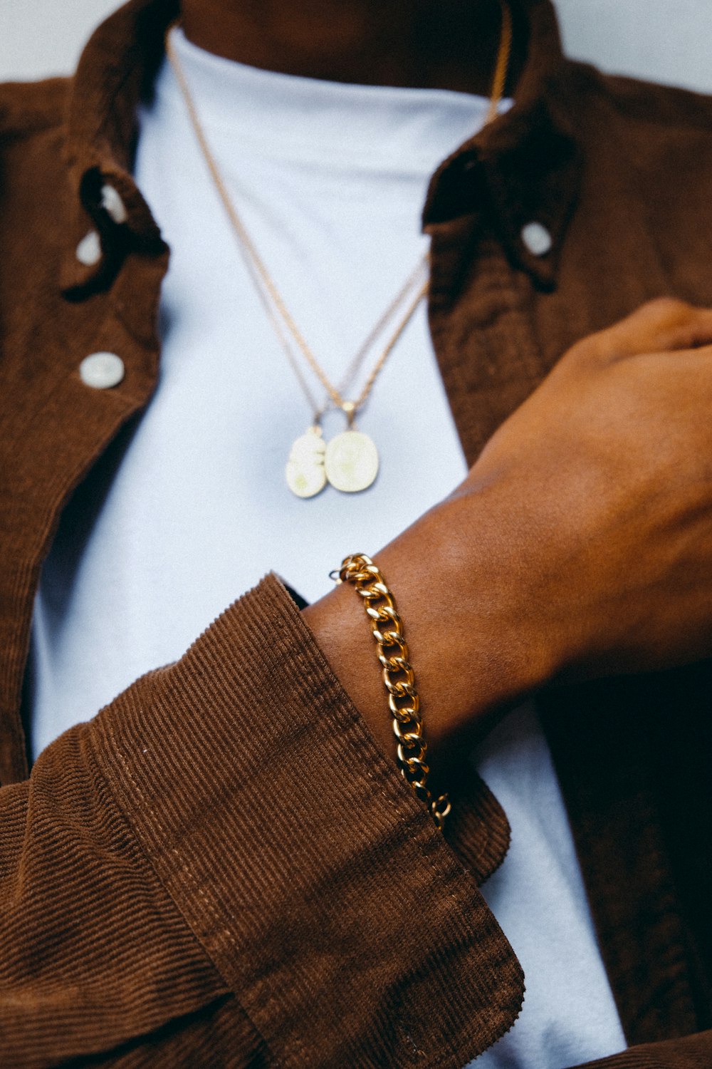 a close up of a person wearing a gold chain bracelet