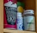 A cupboard shelf holds a variety of packaged goods. On the left, there is a red container of Clipper hot chocolate with bold, white lettering. Next to it, there’s a blue and white bottle, partially obscured, and a vitamin B12 supplement bottle with a green and beige label.