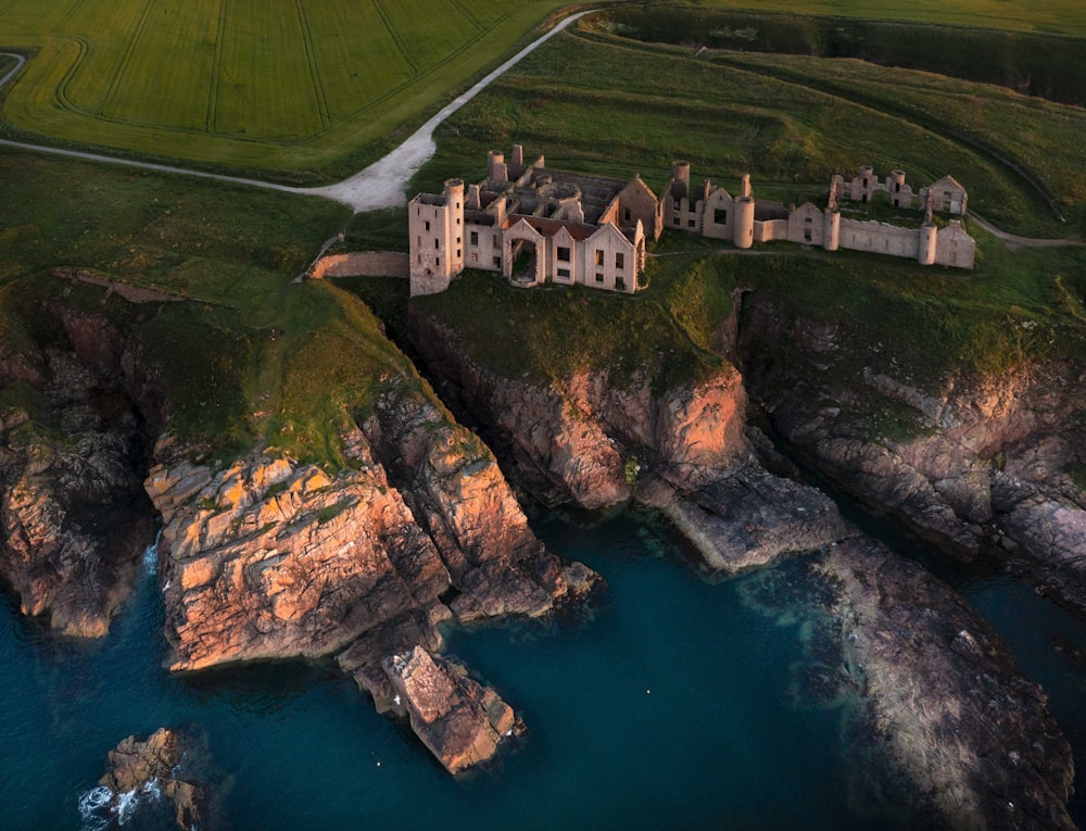 an aerial view of a castle on a cliff near a body of water
