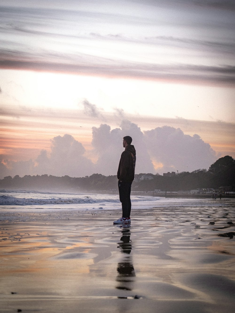 a man standing on a beach next to the ocean