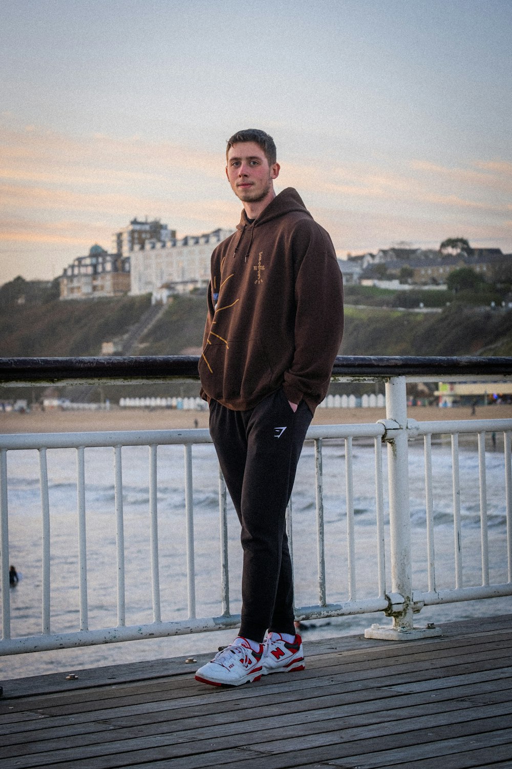 Un homme debout sur une jetée au bord de l’océan