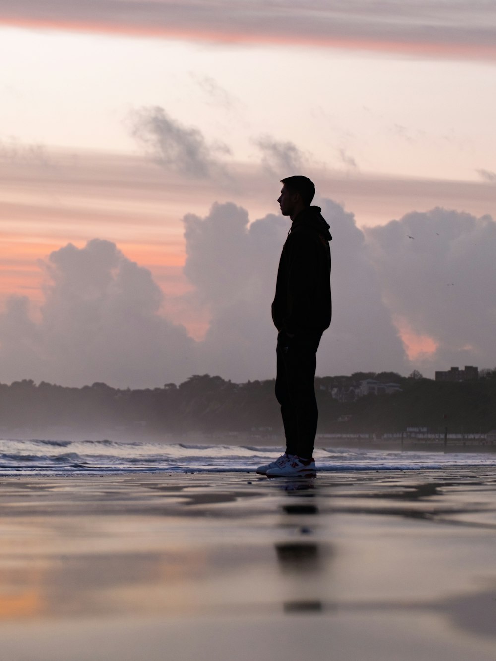 a man standing on a surfboard on the beach