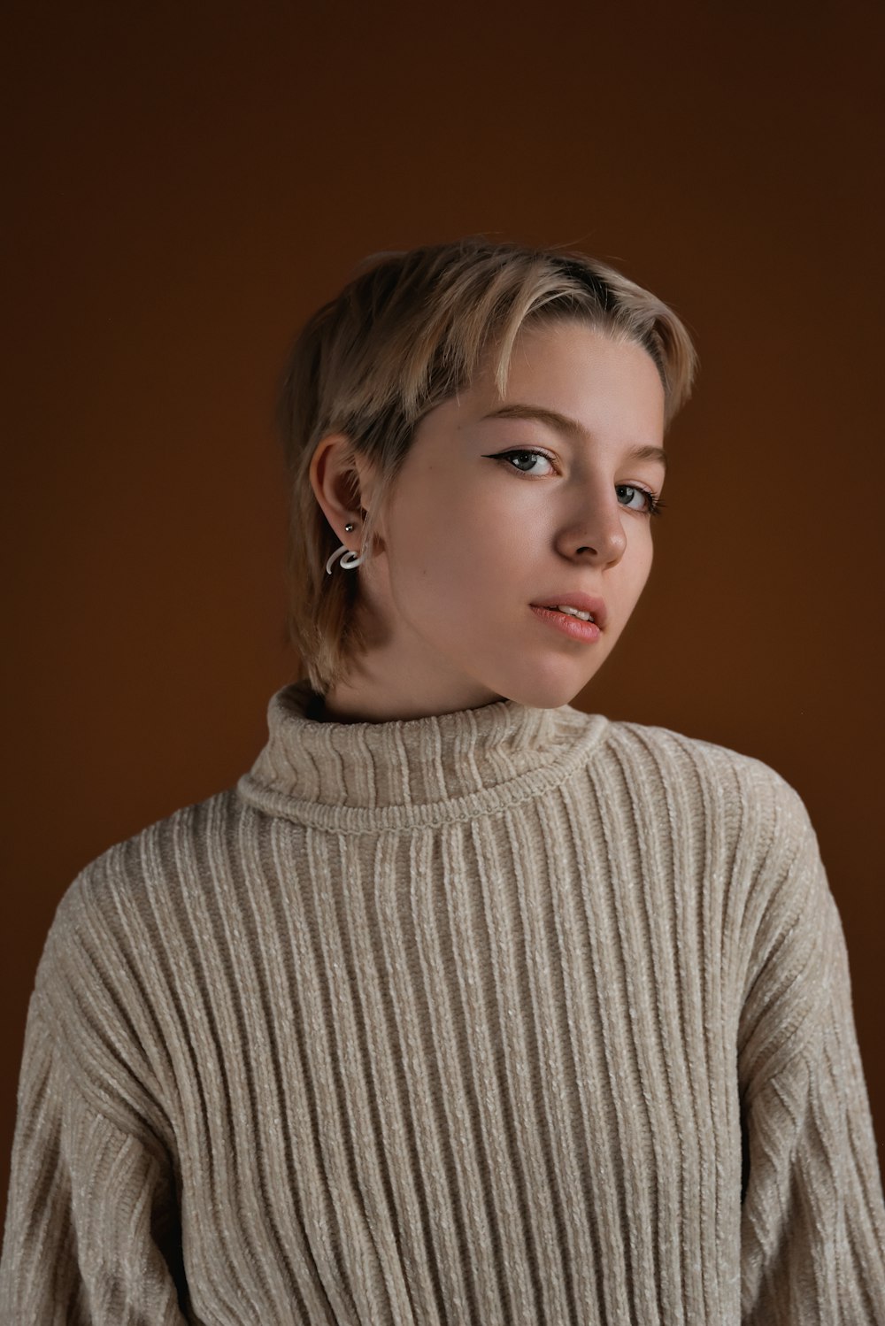 a woman in a turtle neck sweater posing for a picture