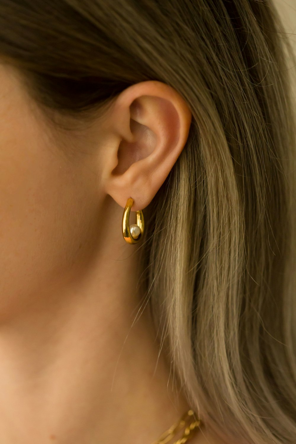 a close up of a person wearing a pair of earrings