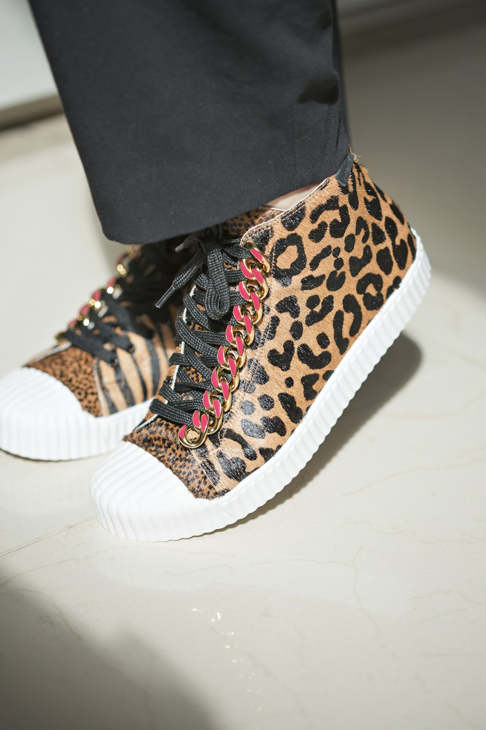 a close up of a person wearing leopard print sneakers