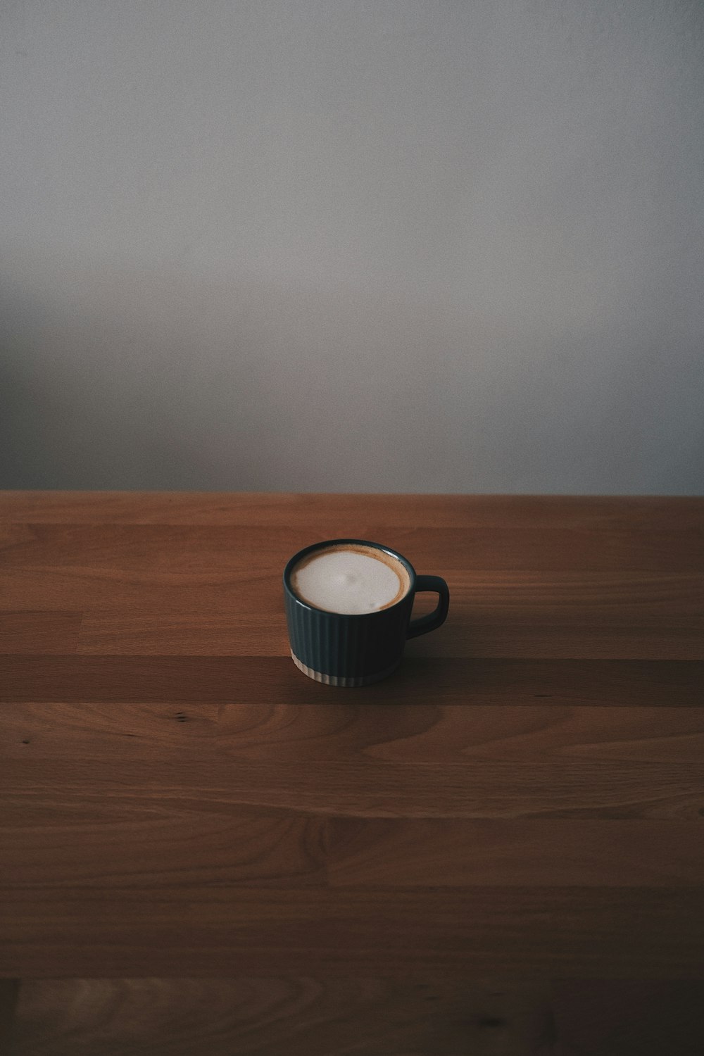 a cup sitting on top of a wooden table