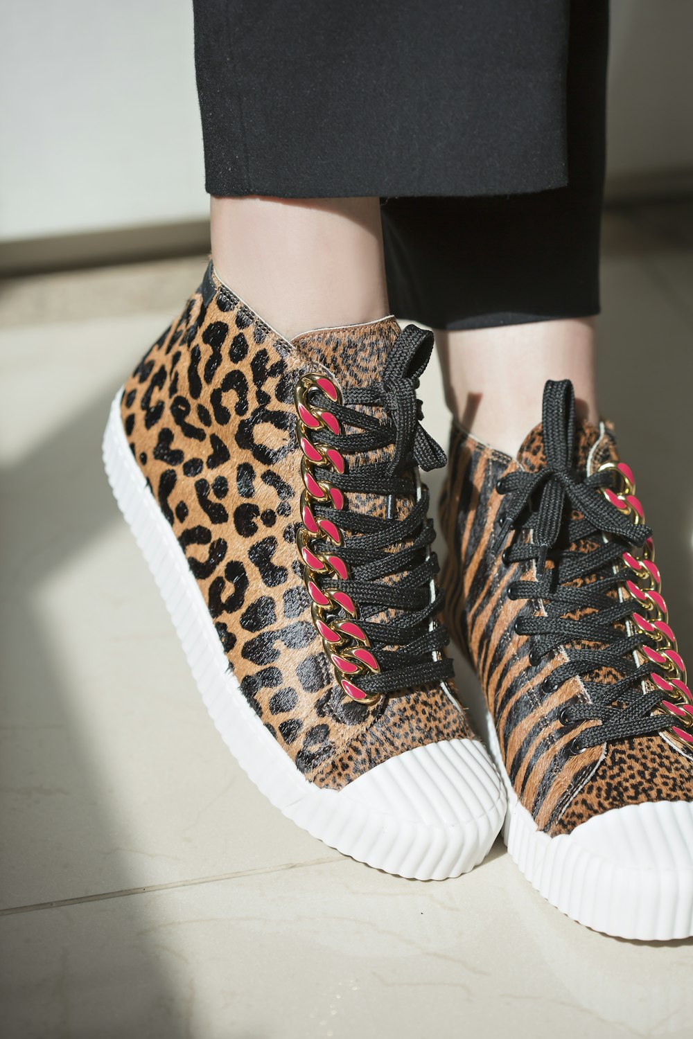 a close up of a person wearing leopard print sneakers