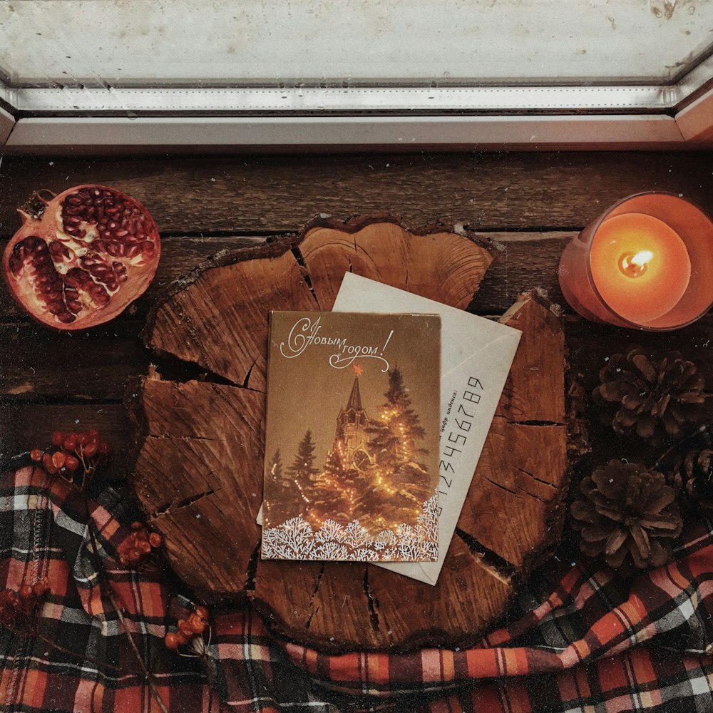 a book sitting on top of a wooden table next to a candle