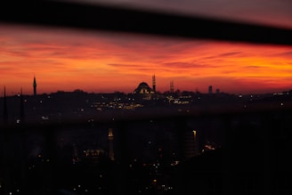 A thoughtful journalist writing notes with a Middle Eastern cityscape in the background during sunset