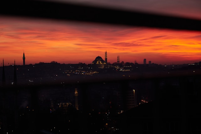 A thoughtful journalist writing notes with a Middle Eastern cityscape in the background during sunset