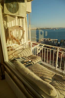 Sunlit balcony overlooking a peaceful neighborhood with comfortable seating.