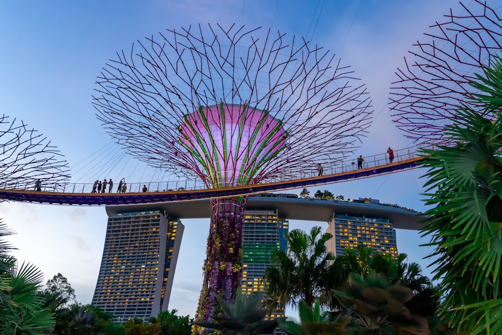 people walking on a bridge over a river next to tall buildings