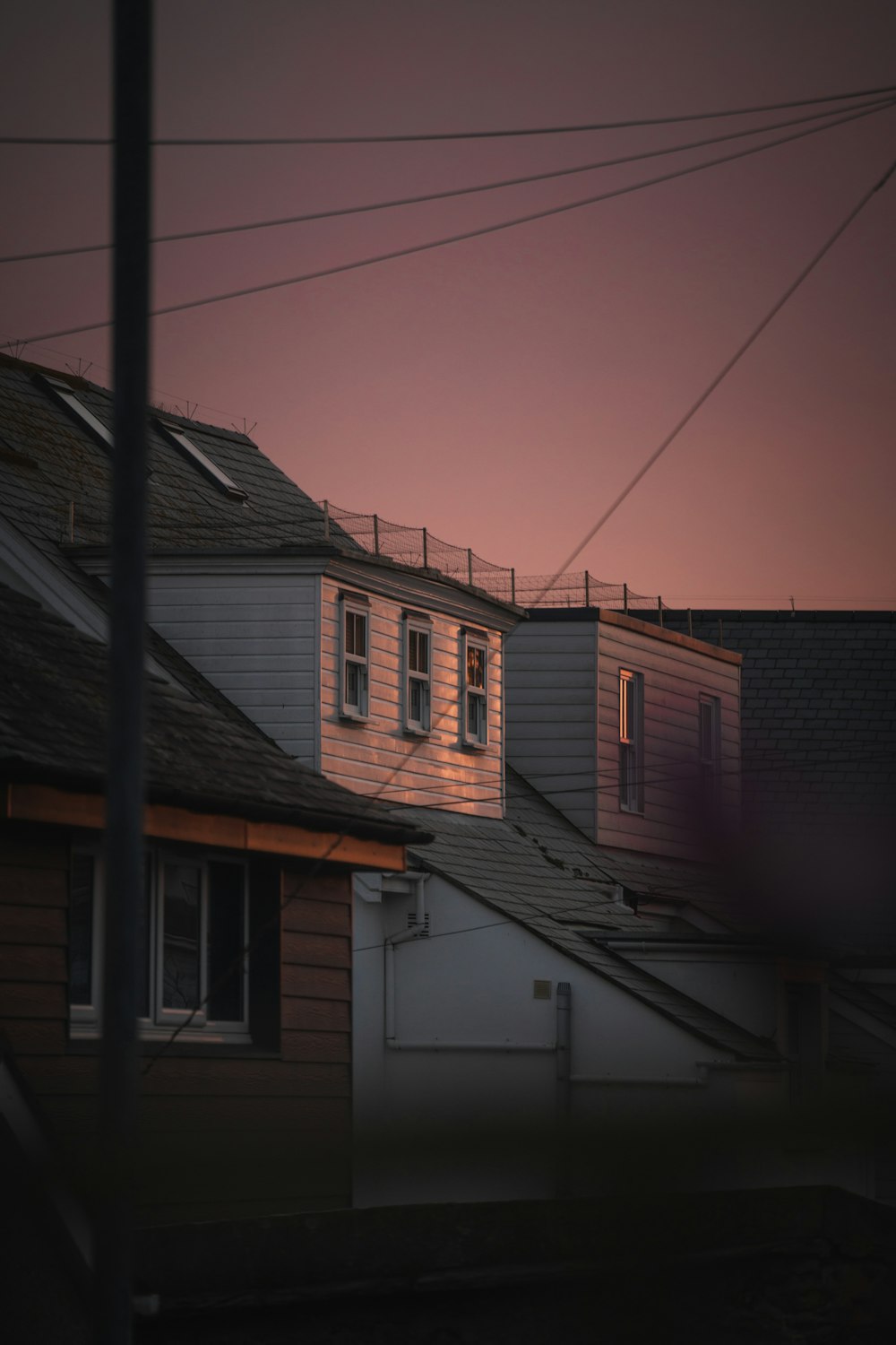 a row of houses with a pink sky in the background