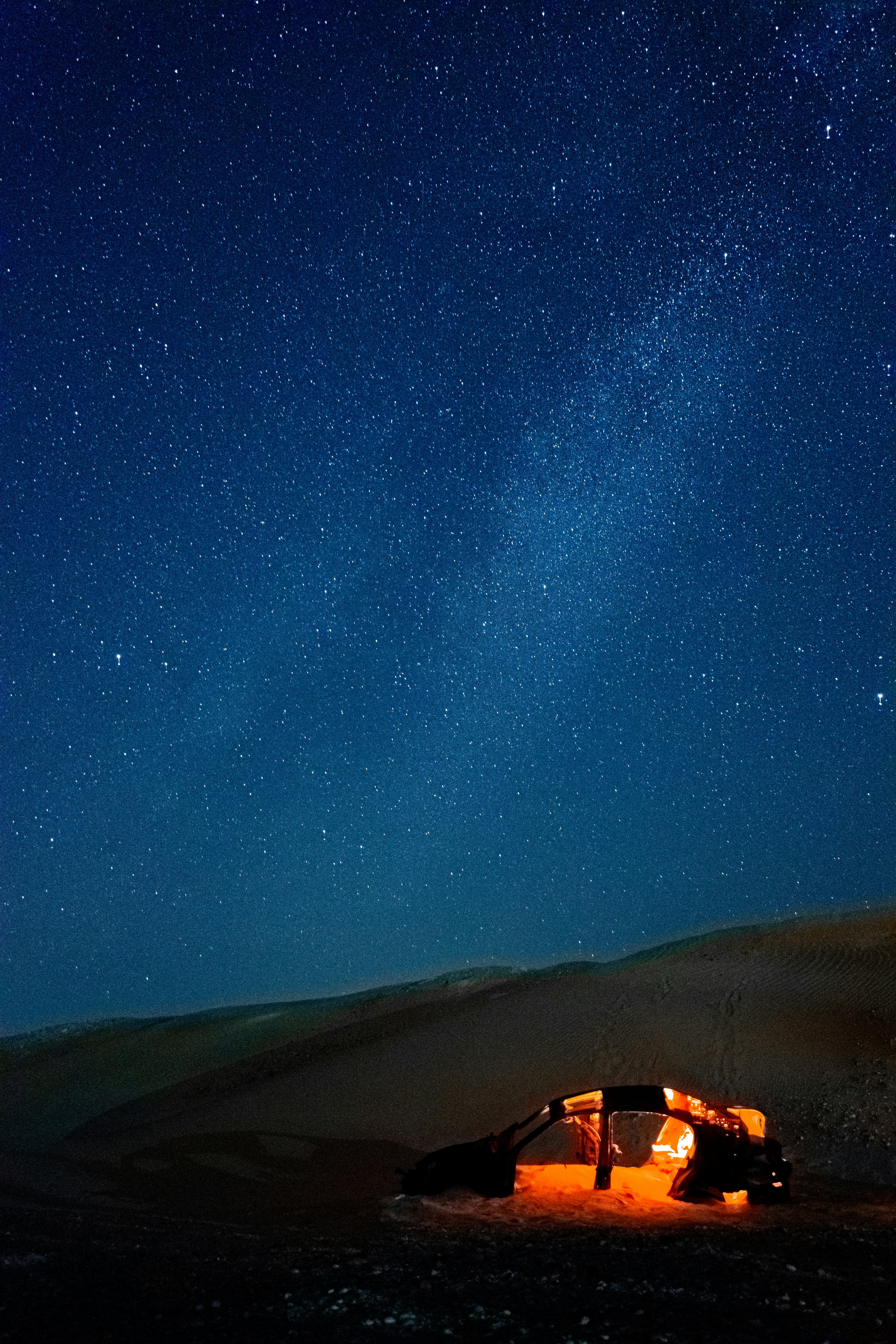 A tent in the middle of a desert under a night sky filled with stars ...