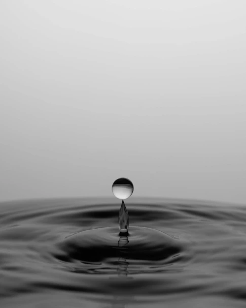 a black and white photo of a drop of water