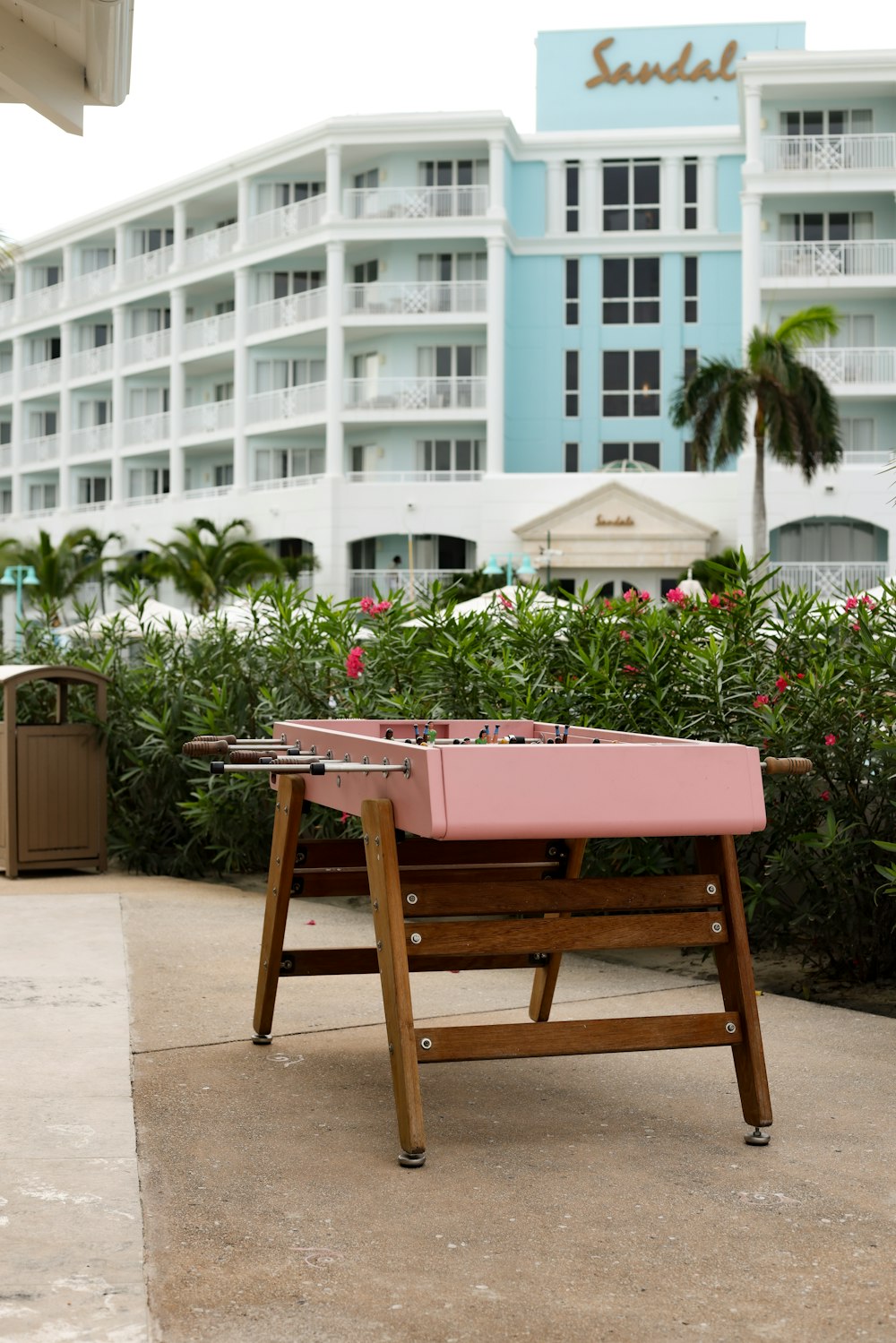 Un banco rosa sentado frente a un hotel