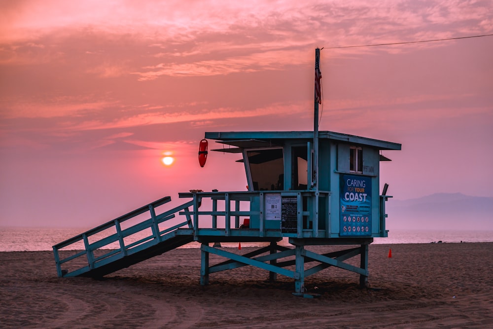 a lifeguard tower sitting on top of a sandy beach