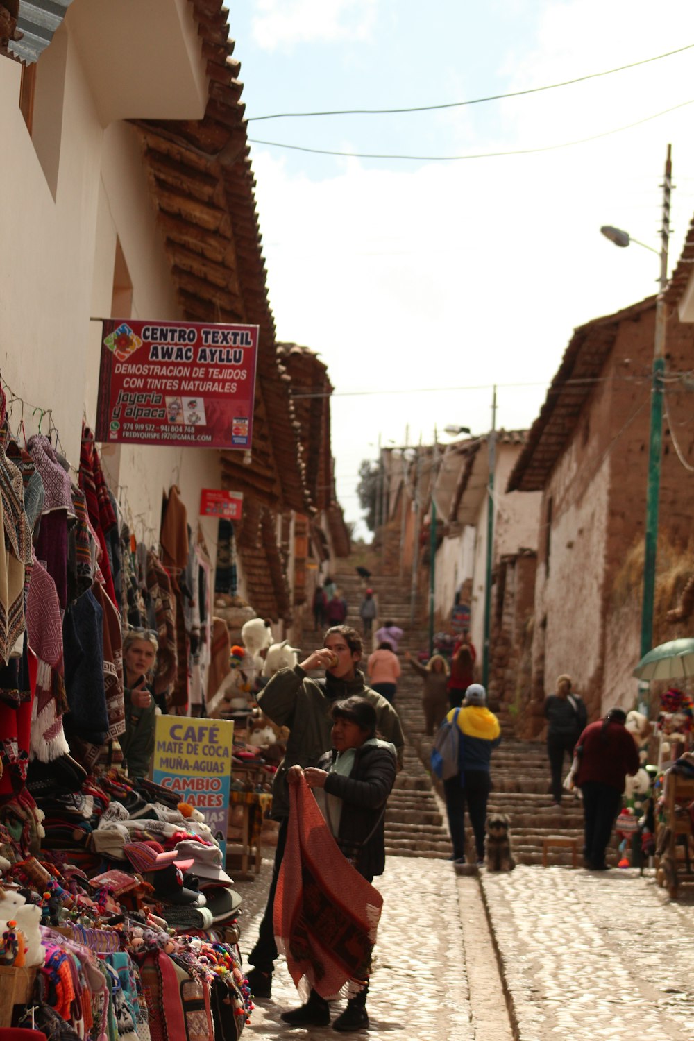 a narrow street lined with shops and people