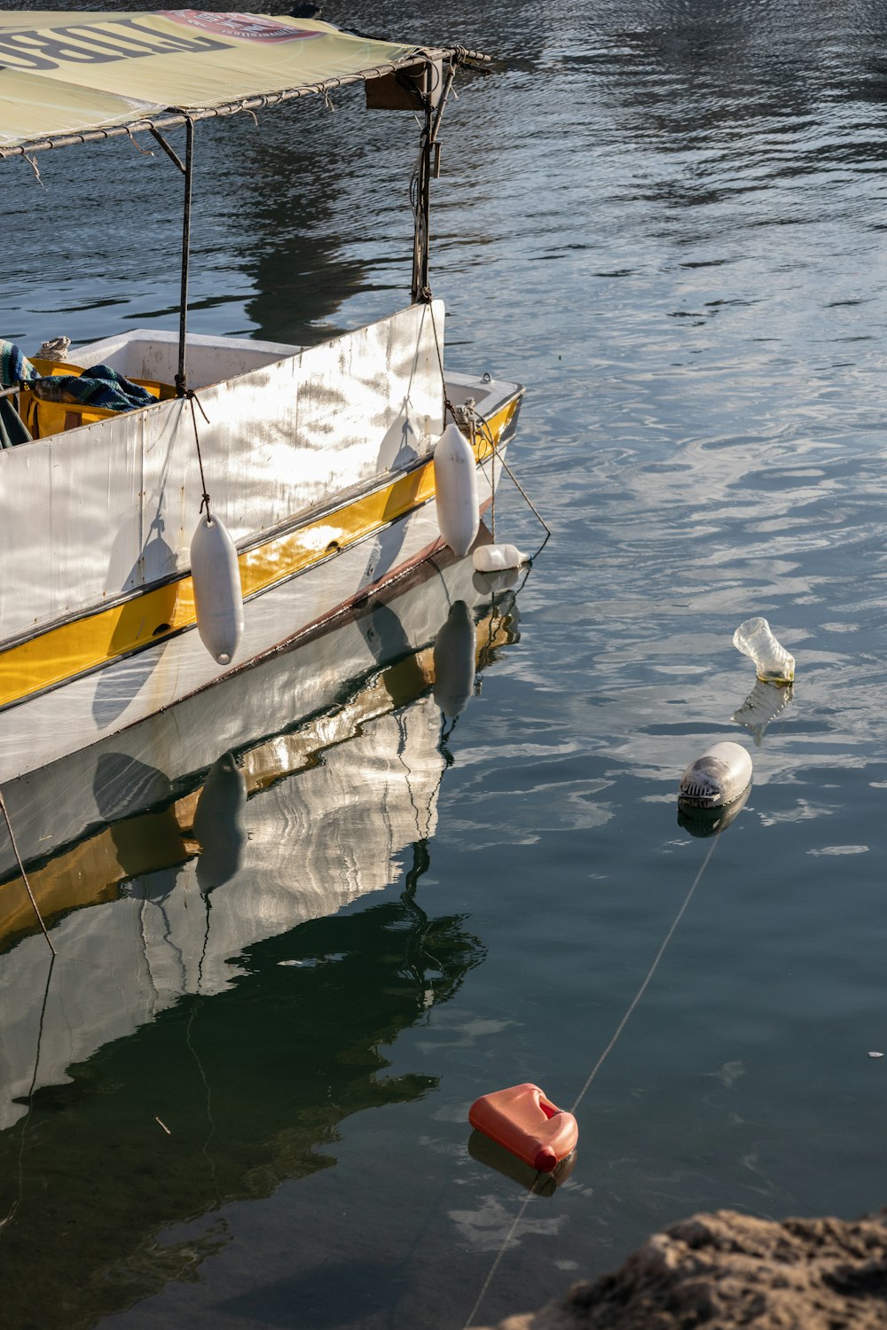 a yellow and white boat in a body of water