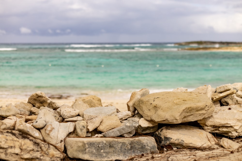 un tas de rochers assis au sommet d’une plage de sable