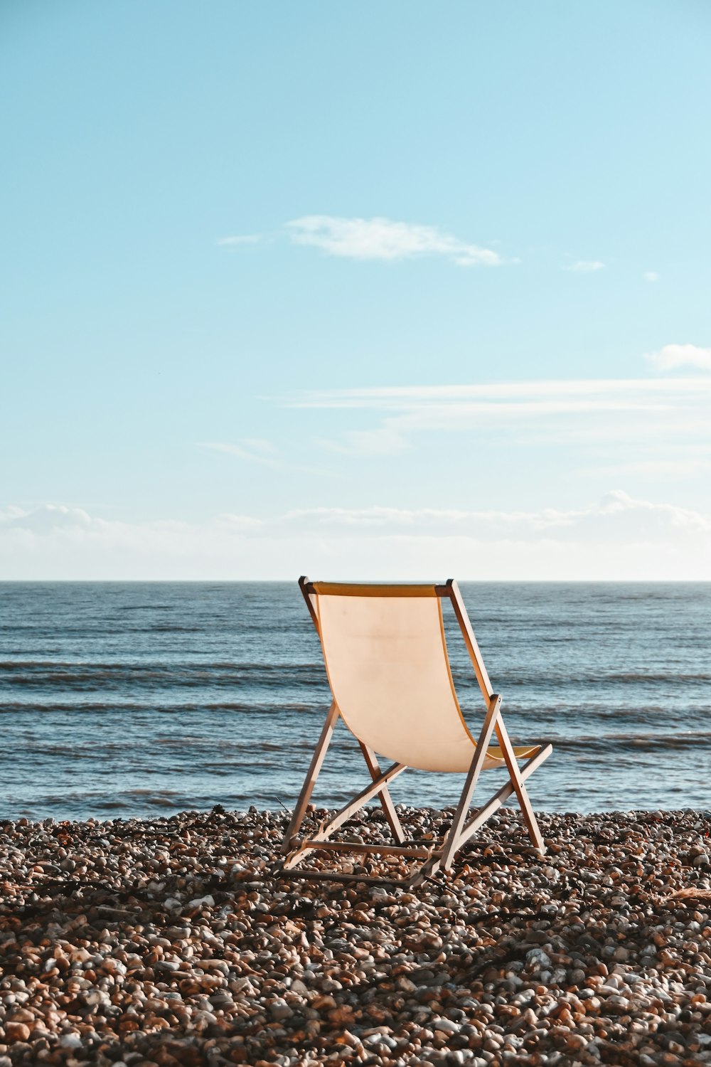 a chair sitting on top of a rocky beach