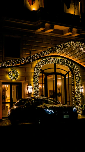 A luxurious limousine waiting outside the grand entrance of rakvegas at night.