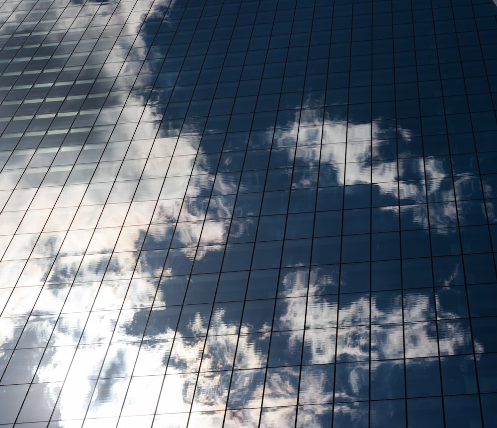 the reflection of clouds in the windows of a building