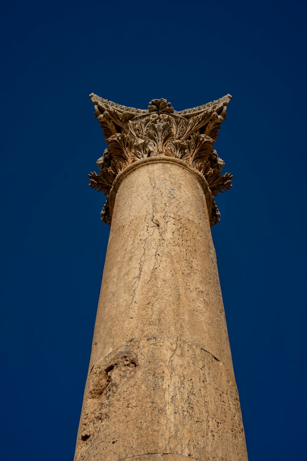 the top of a tall pillar with a statue on top of it