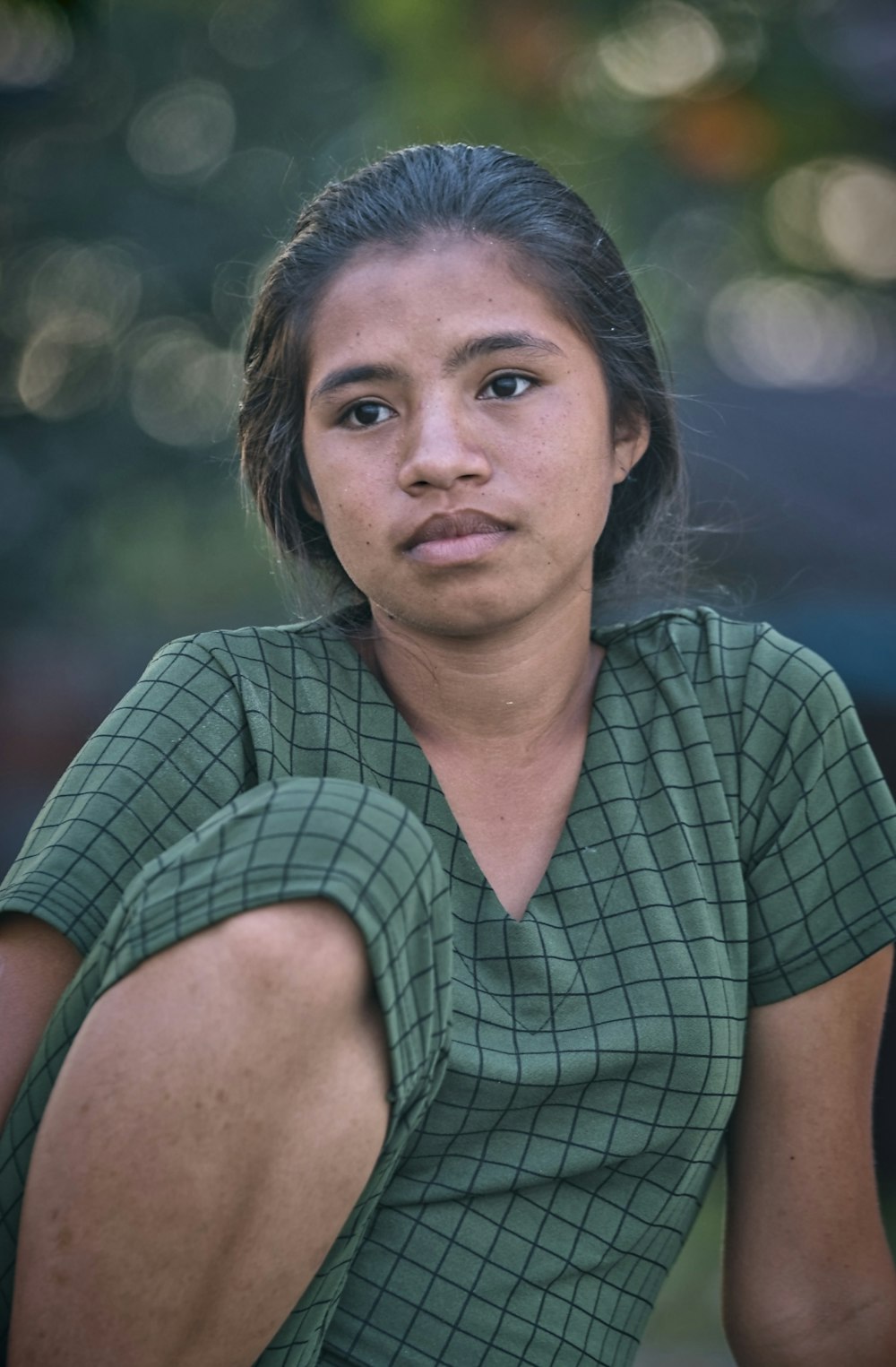 a woman with a green shirt is sitting down