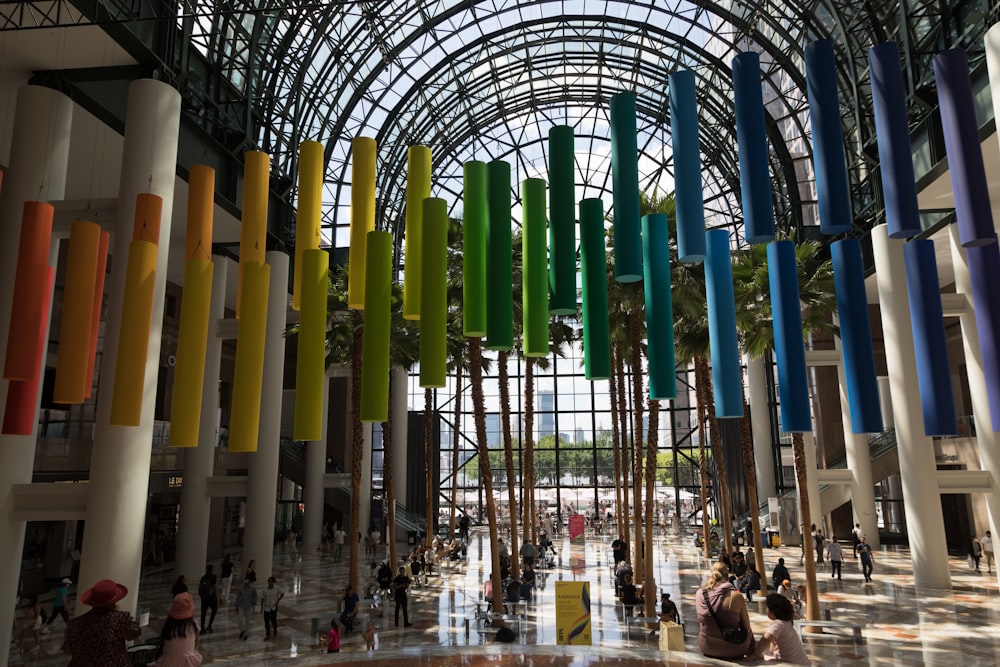 a group of people standing in a building with colorful columns