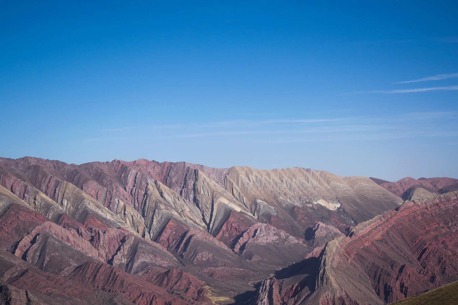 a view of a mountain range from the top of a hill