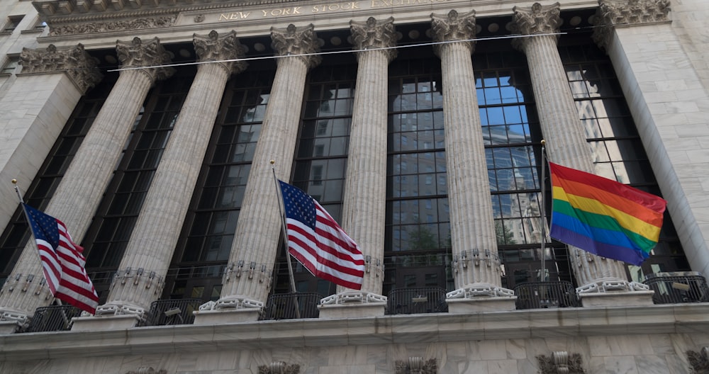 a group of flags flying in front of a building