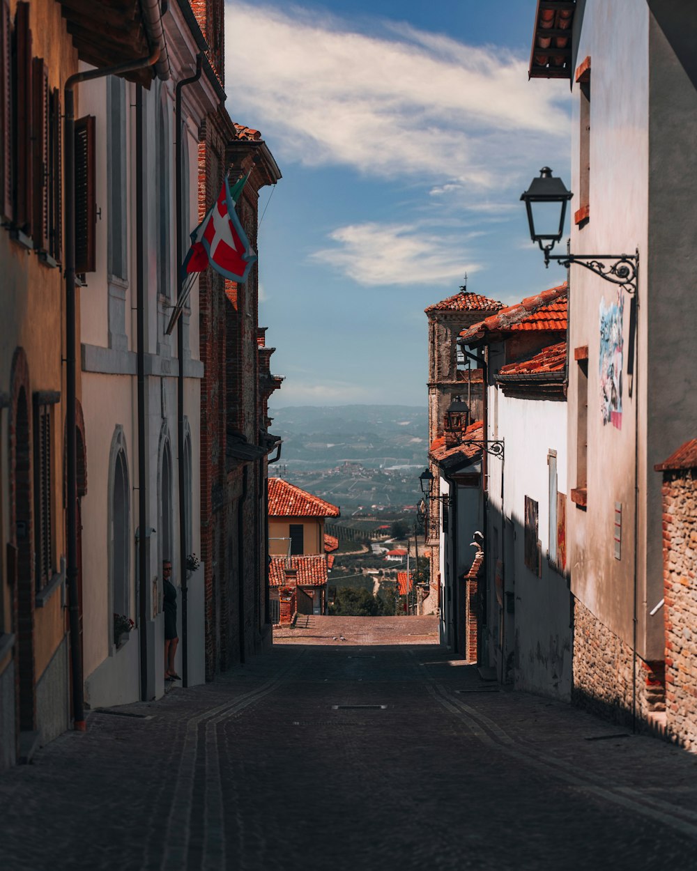 a narrow street with a lamp post in the middle of it