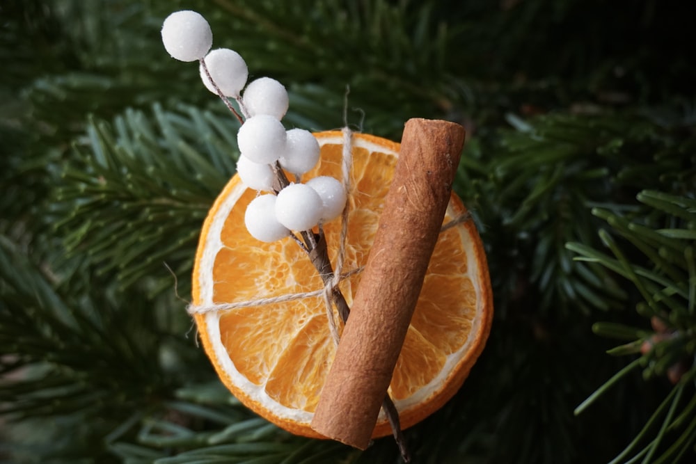 a cinnamon stick and an orange slice on a christmas ornament