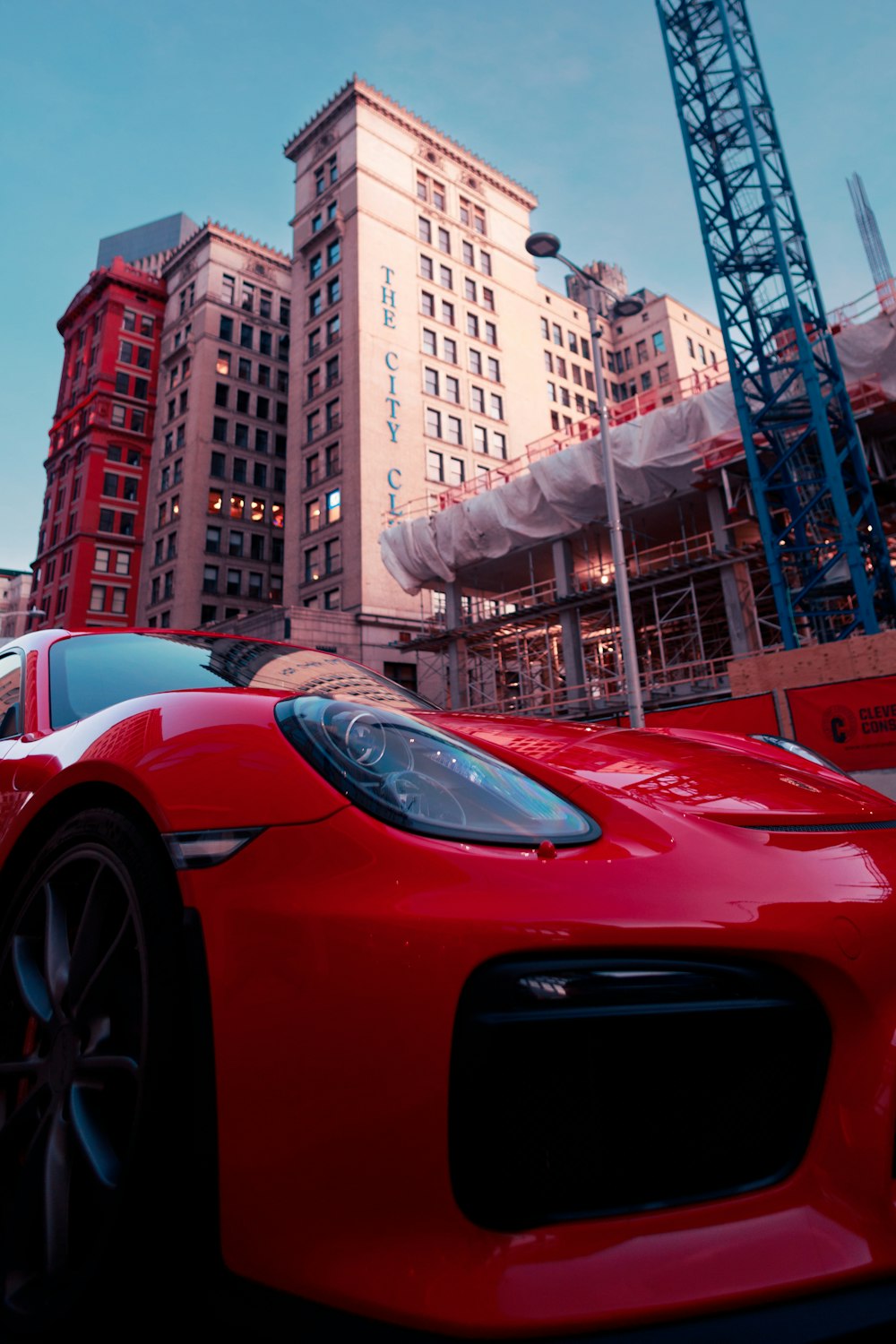 a red sports car parked in front of a tall building