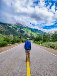a man walking down the middle of a road