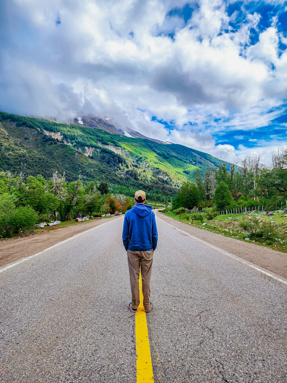 a man walking down the middle of a road