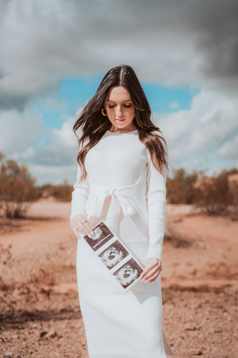 Una mujer con un vestido blanco sosteniendo una barra de chocolate