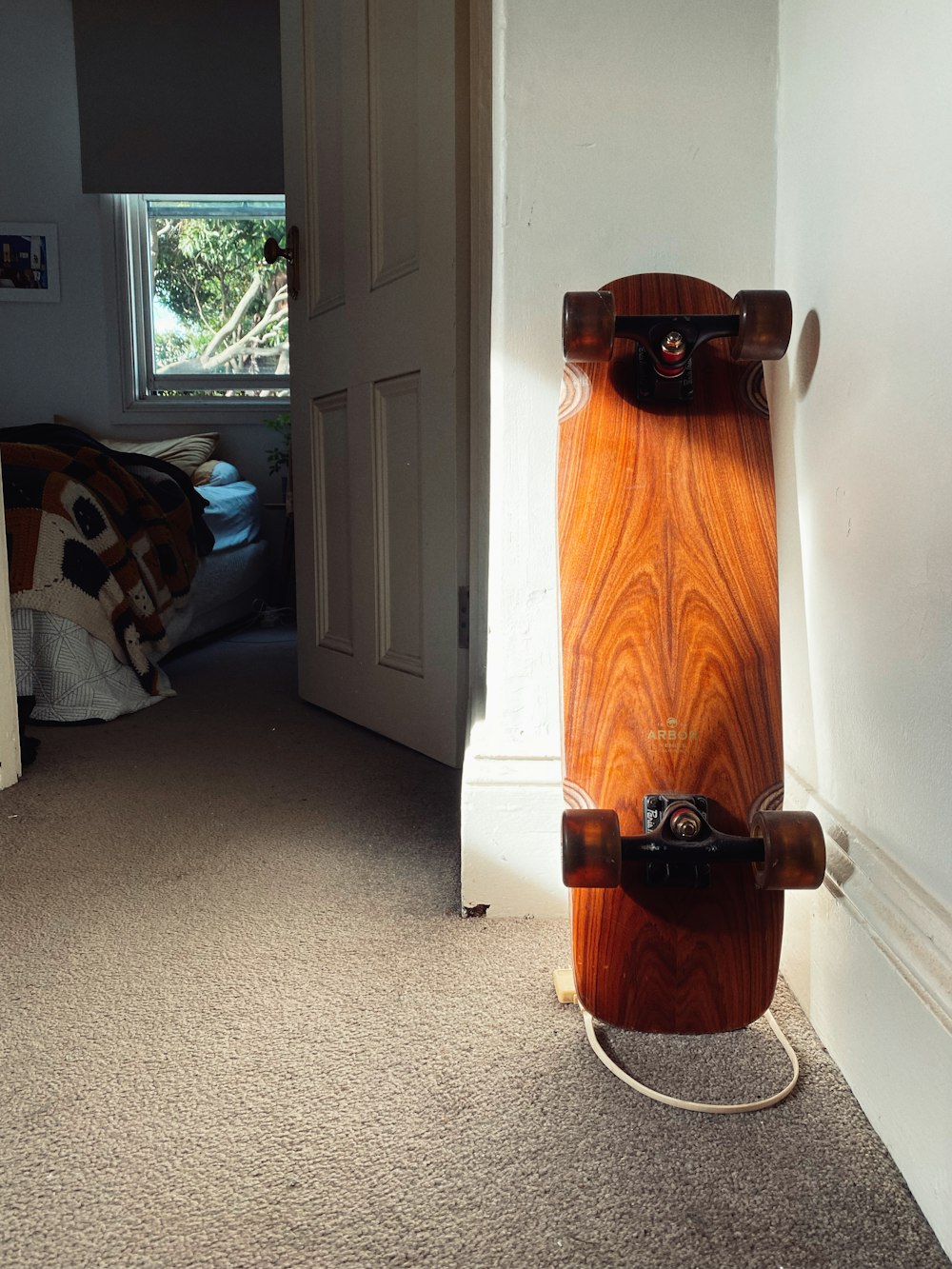 a skateboard propped up against a wall in a bedroom