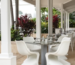 a table and chairs on a patio with palm trees in the background