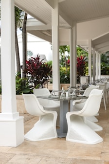 a table and chairs on a patio with palm trees in the background