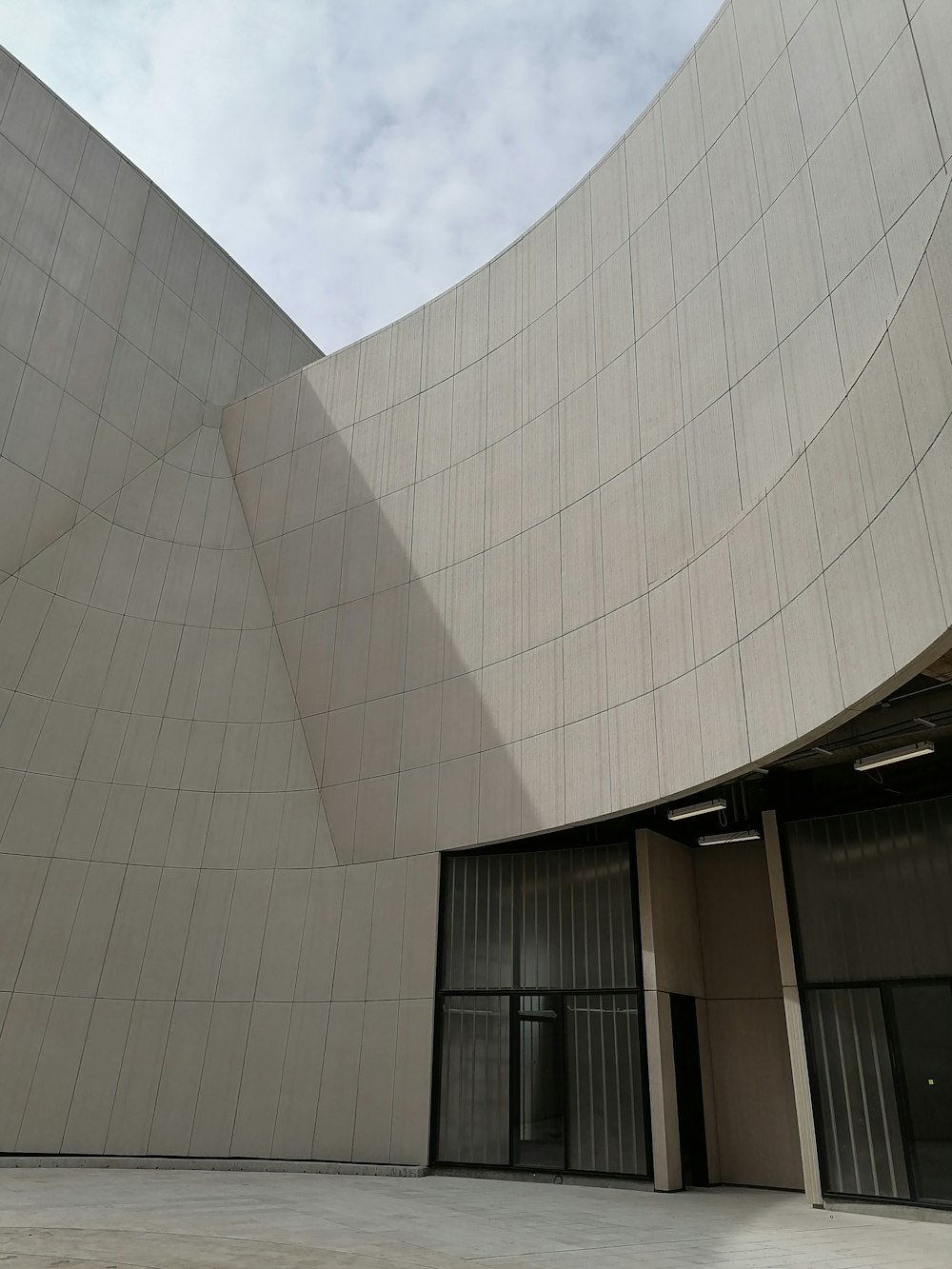 a building with a curved roof and a clock on the front of it