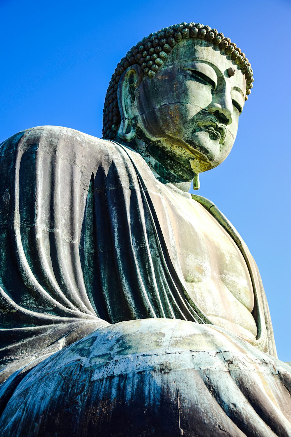 Una gran estatua de Buda sentada frente a un cielo azul
