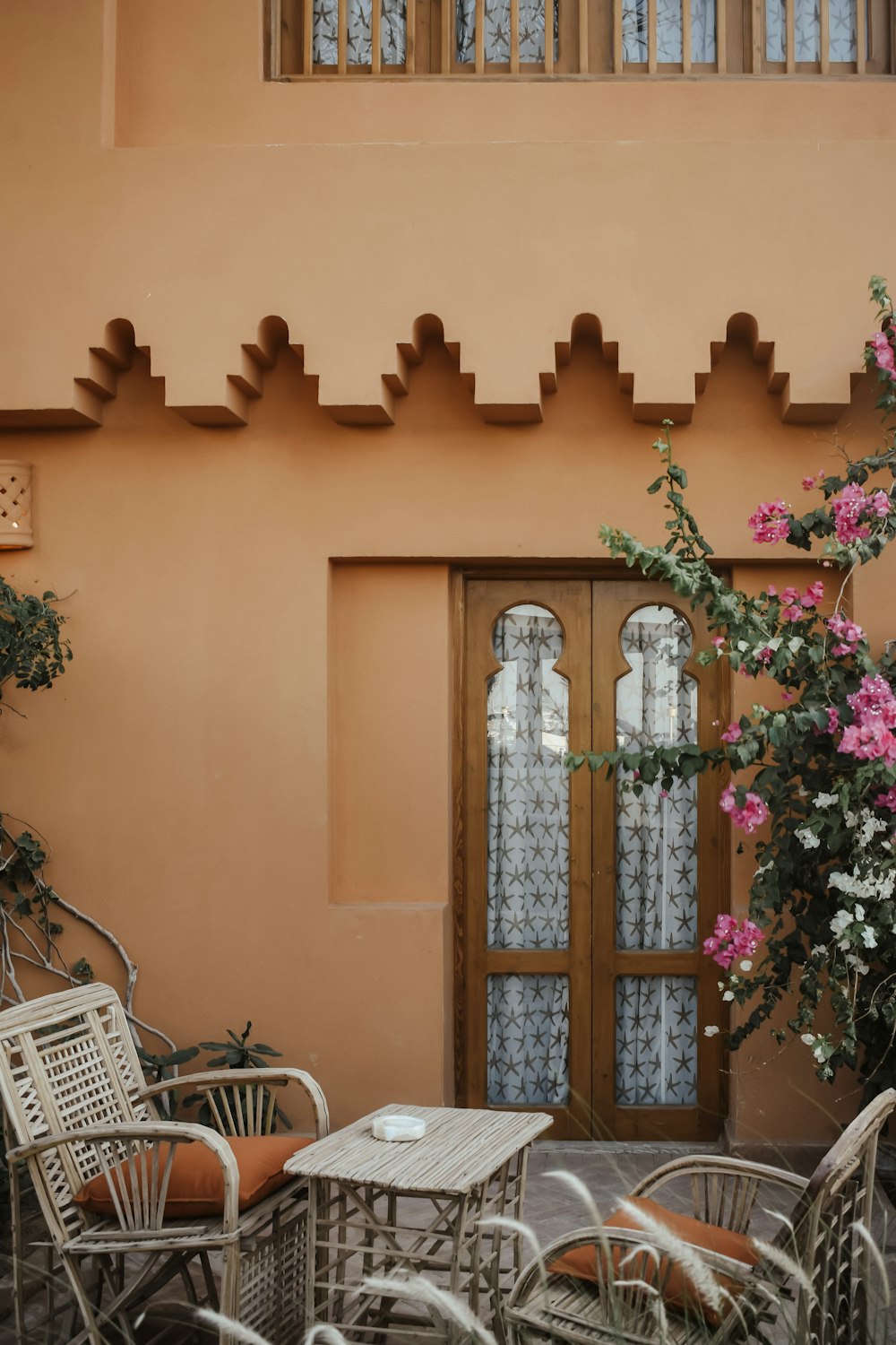 a patio with a table and chairs and a potted plant