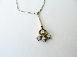 a silver necklace with a bunch of beads hanging from it