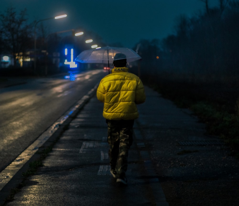 a man walking down a street holding an umbrella