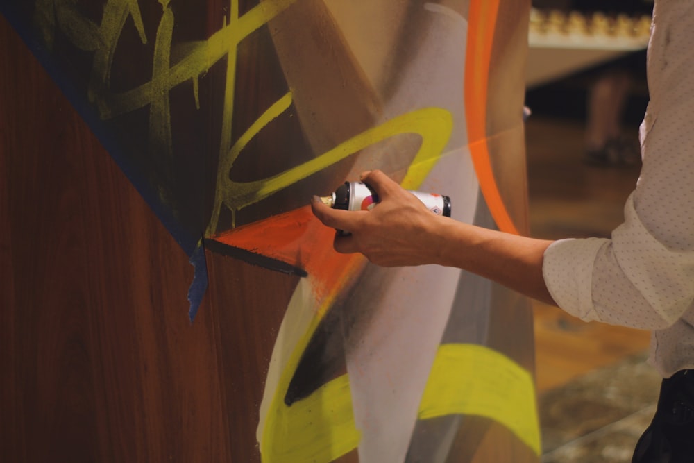 a person is painting a wall with a brush