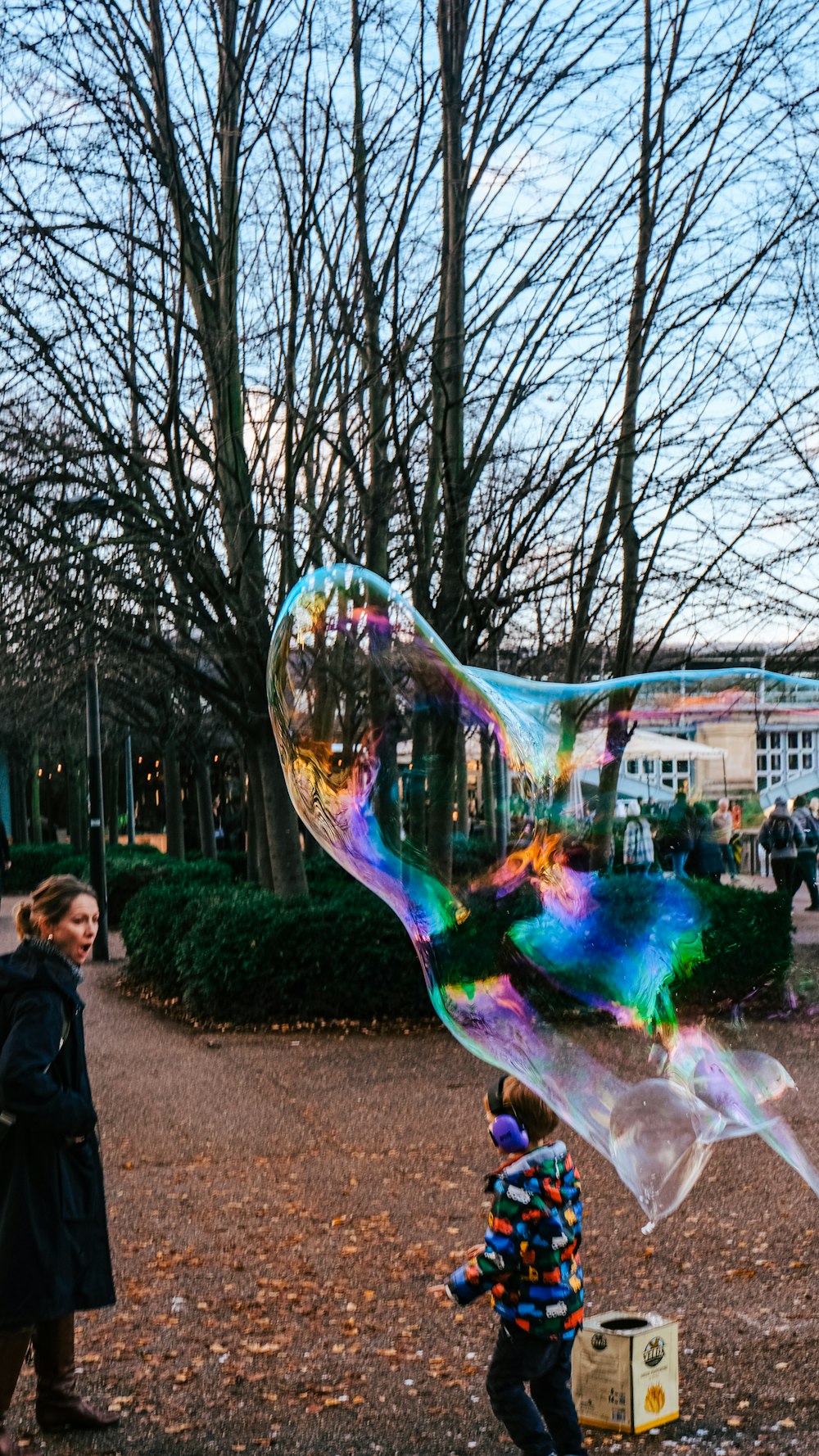 a woman and a child playing with a large bubble