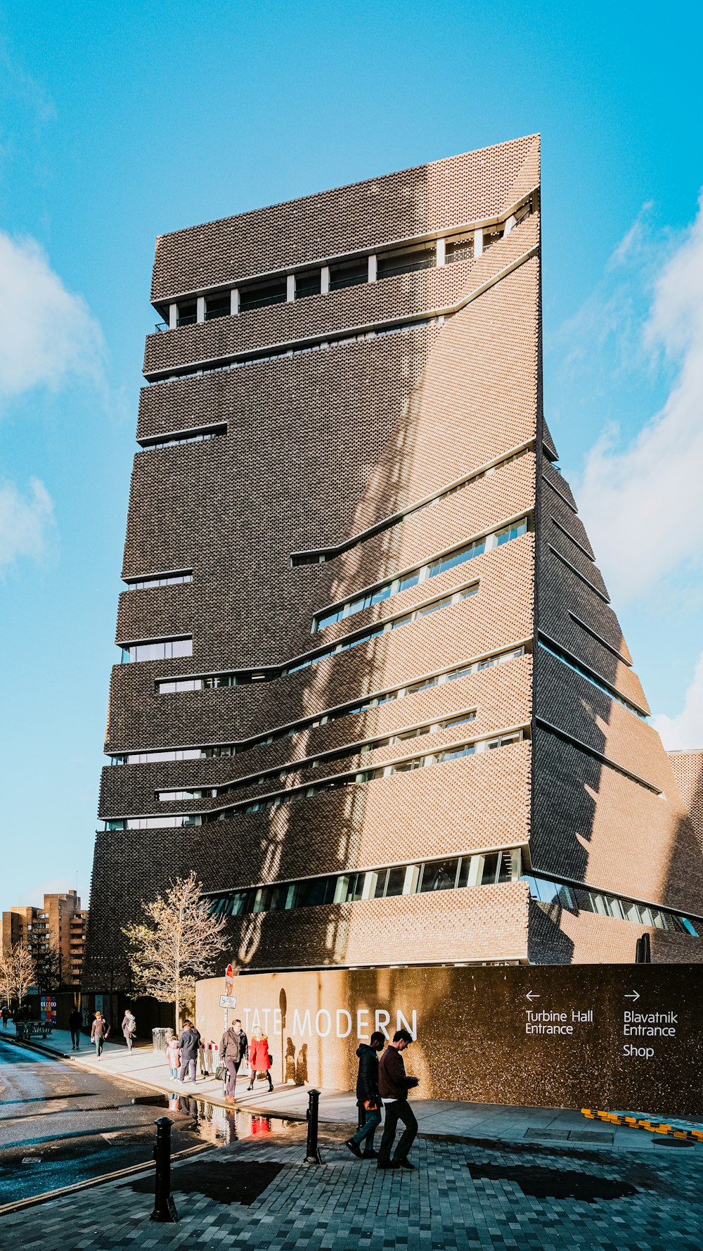 a tall building with people walking in front of it