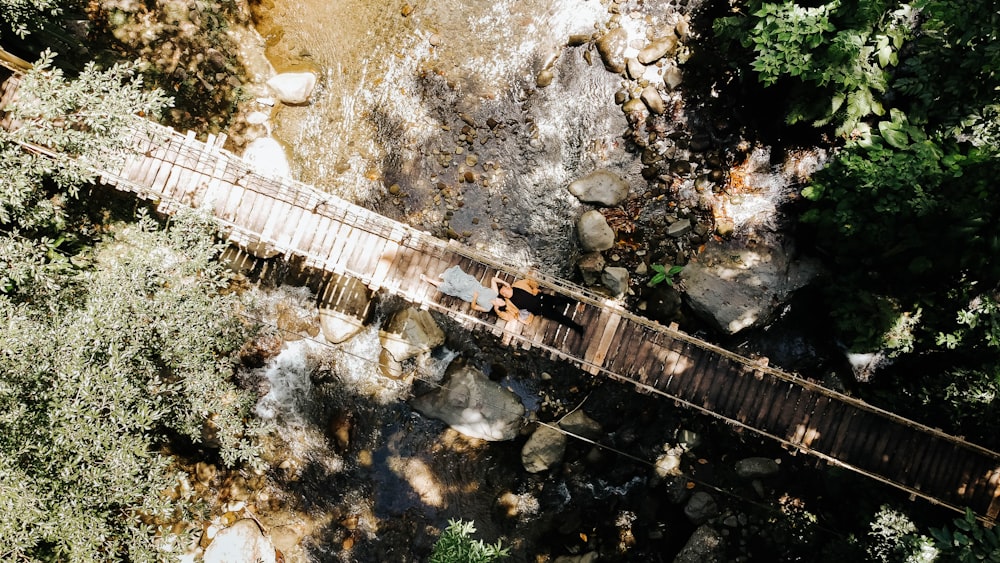 an aerial view of a wooden bridge over a river